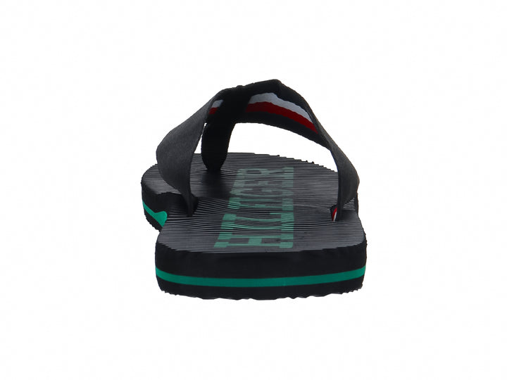 Sandalias Tommy Hilfiger color negro con detalle en la suela color verde y textura estriada.