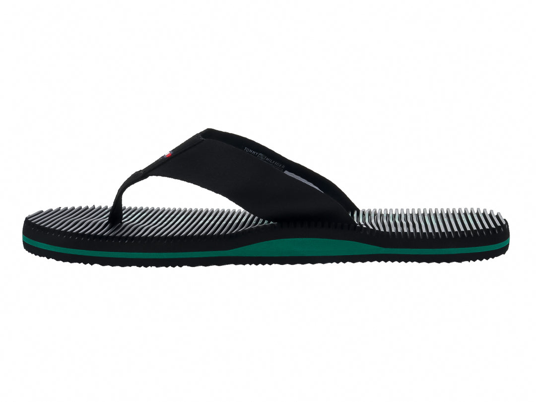 Sandalias Tommy Hilfiger color negro con detalle en la suela color verde y textura estriada.