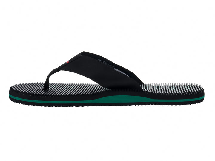 Sandalias Tommy Hilfiger color negro con detalle en la suela color verde y textura estriada.