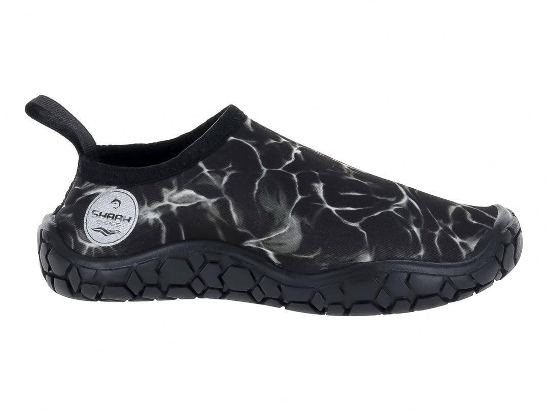 Zapato acuático negro con diseño de camuflaje blanco y suela gruesa de goma negra.