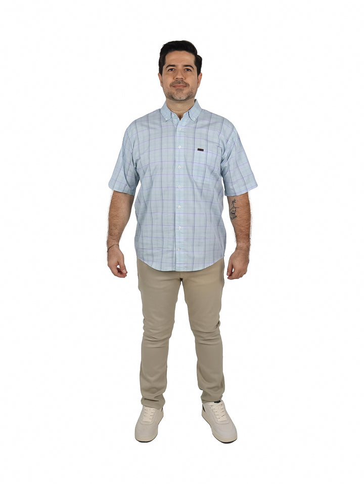 Hombre vistiendo una camisa de manga corta color aqua con estampado de cuadros pequeños.