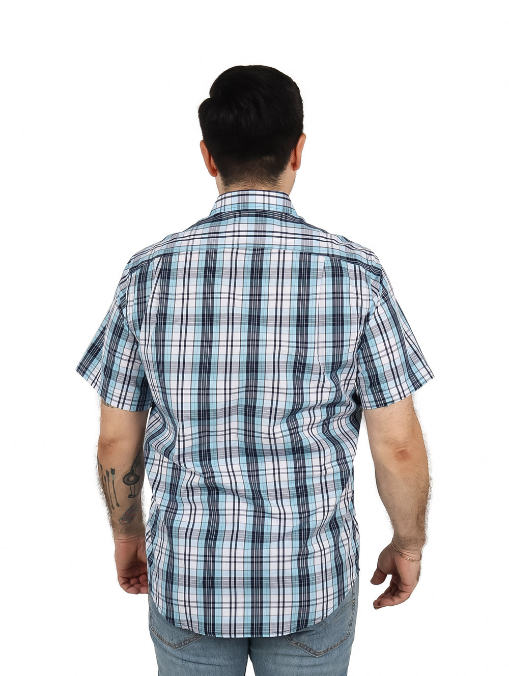 Hombre usando camisa de manga corta con diseño de cuadros en tonos azul y blanco.