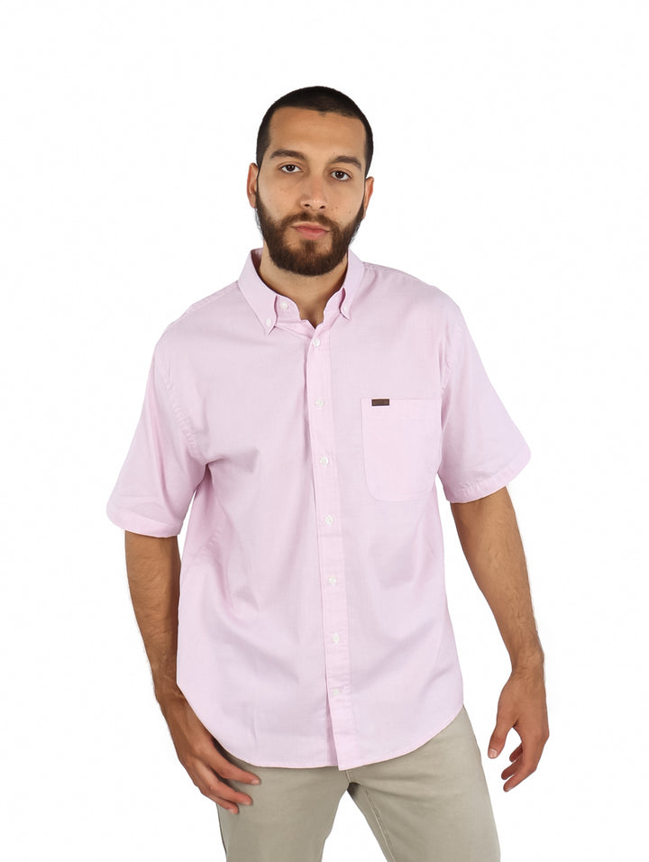 Hombre vistiendo una camisa de color rosa claro de manga corta con botones.