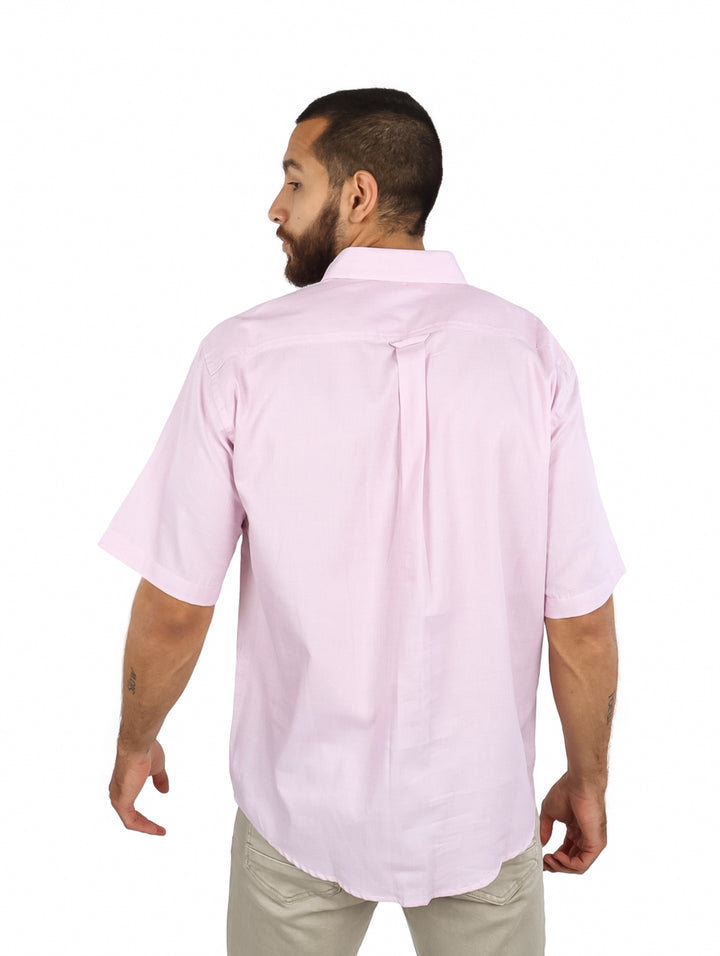 Hombre vistiendo una camisa de color rosa claro de manga corta con botones.