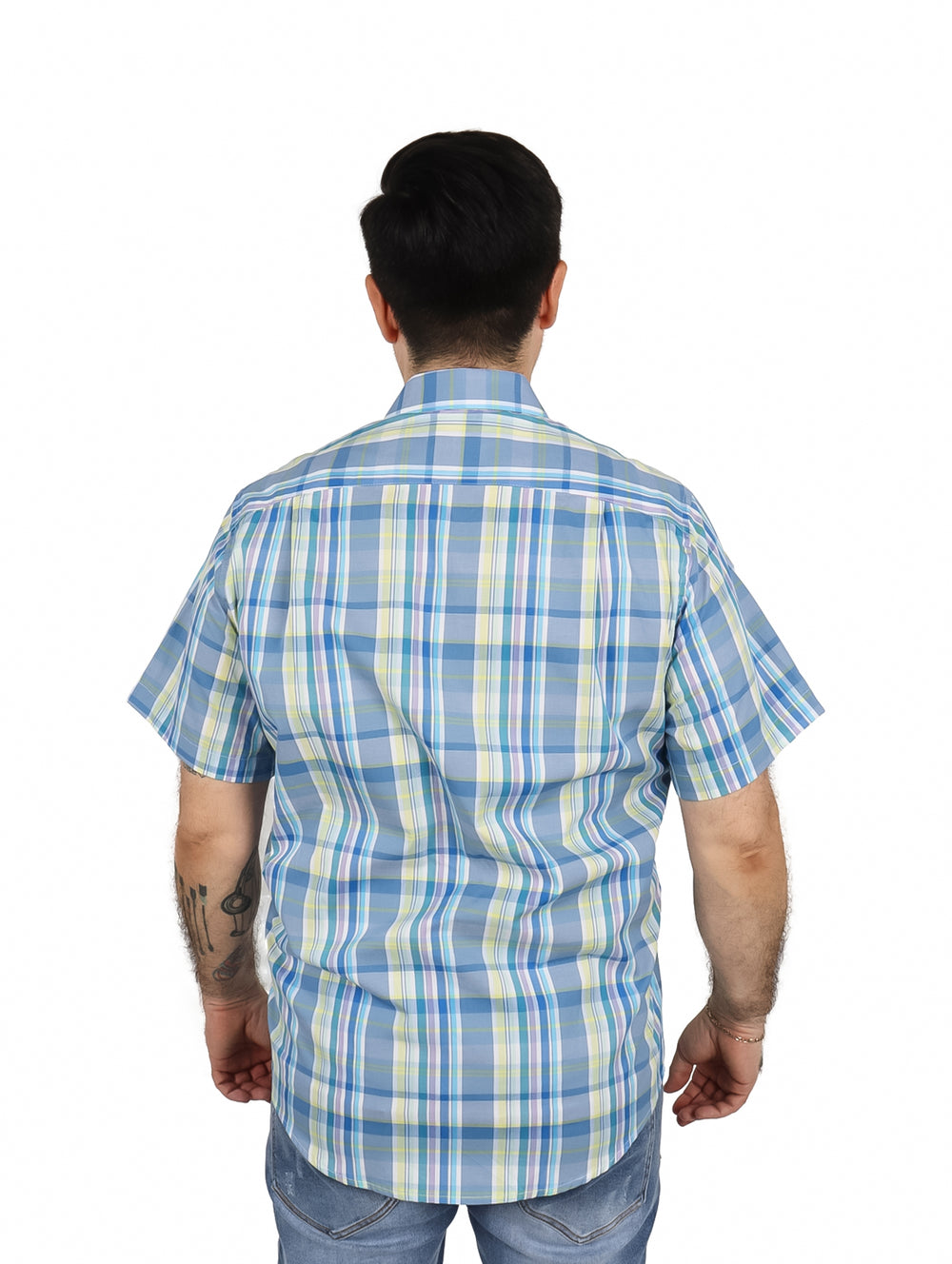 Hombre vistiendo una camisa de manga corta con estampado de cuadros en azul, blanco y amarillo.