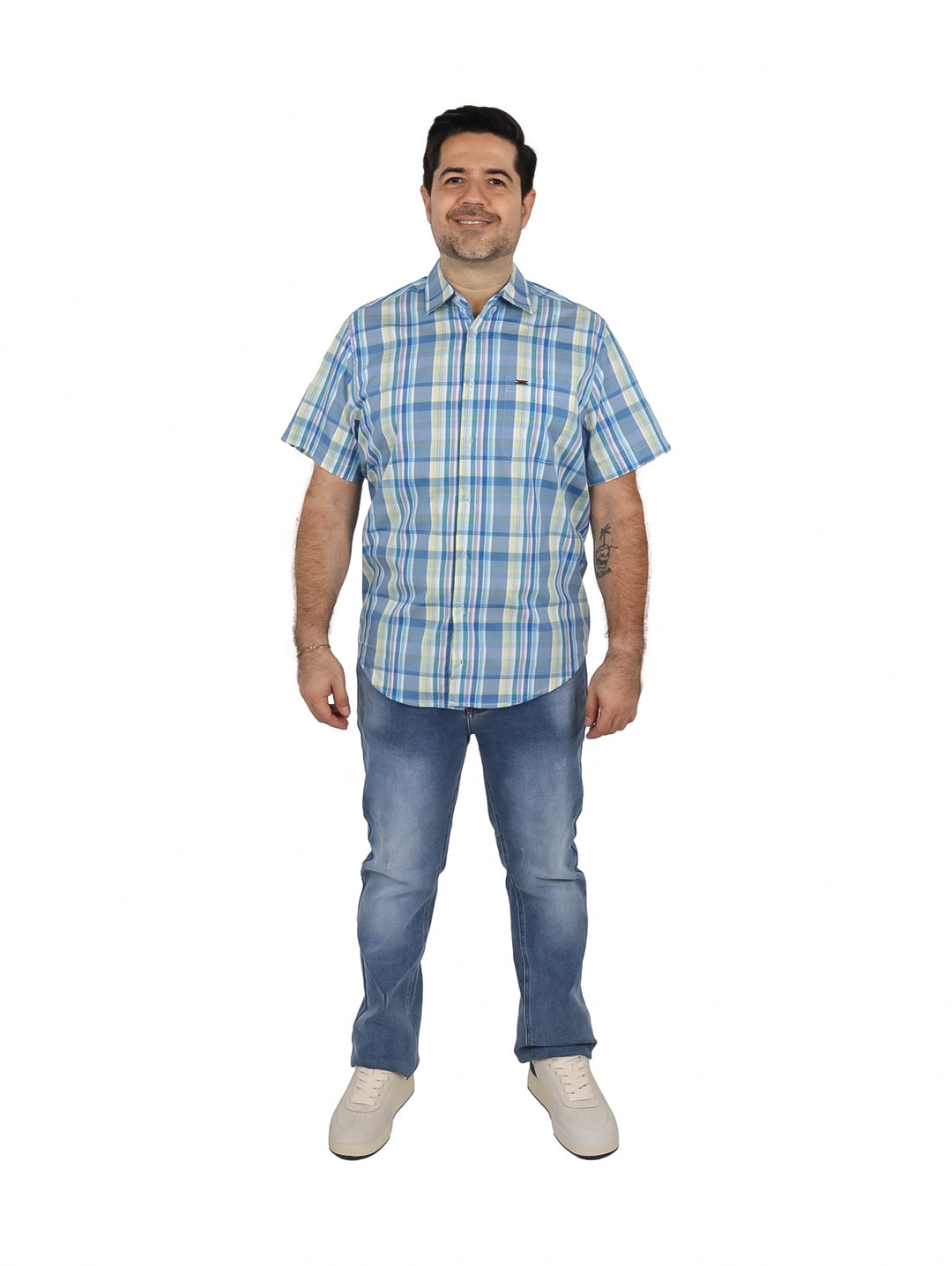 Hombre vistiendo una camisa de manga corta con estampado de cuadros en azul, blanco y amarillo.