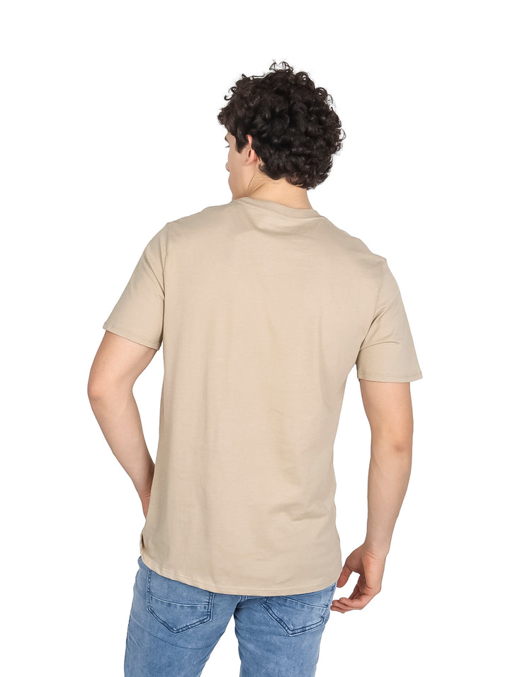 Hombre vistiendo playera Wrangler de color café con estampado de calavera de toro y logo en el pecho.