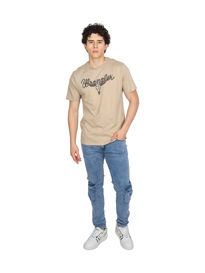 Hombre vistiendo playera Wrangler de color café con estampado de calavera de toro y logo en el pecho.