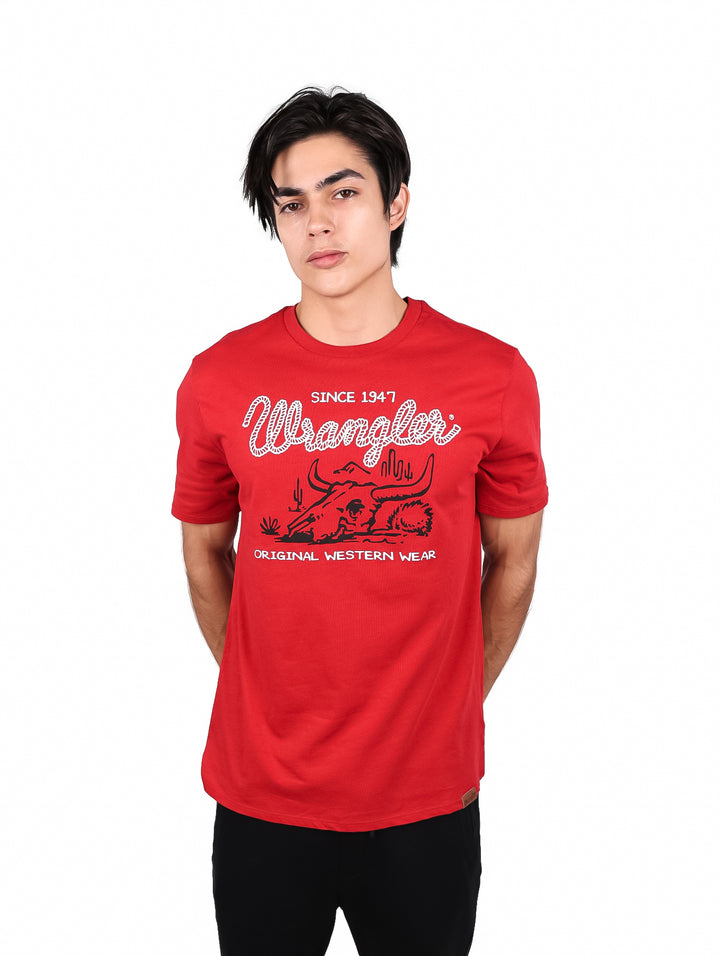 Hombre vistiendo una playera roja de manga corta marca Wrangler con estampado blanco en el pecho.