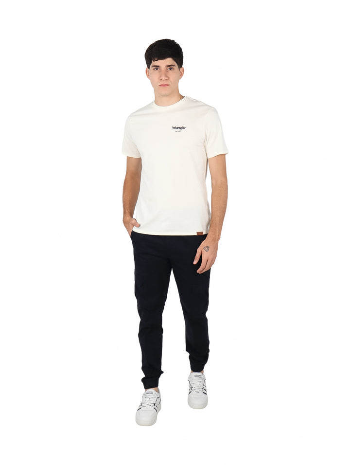 Hombre vistiendo playera Wrangler de color beige con cuello redondo y manga corta.