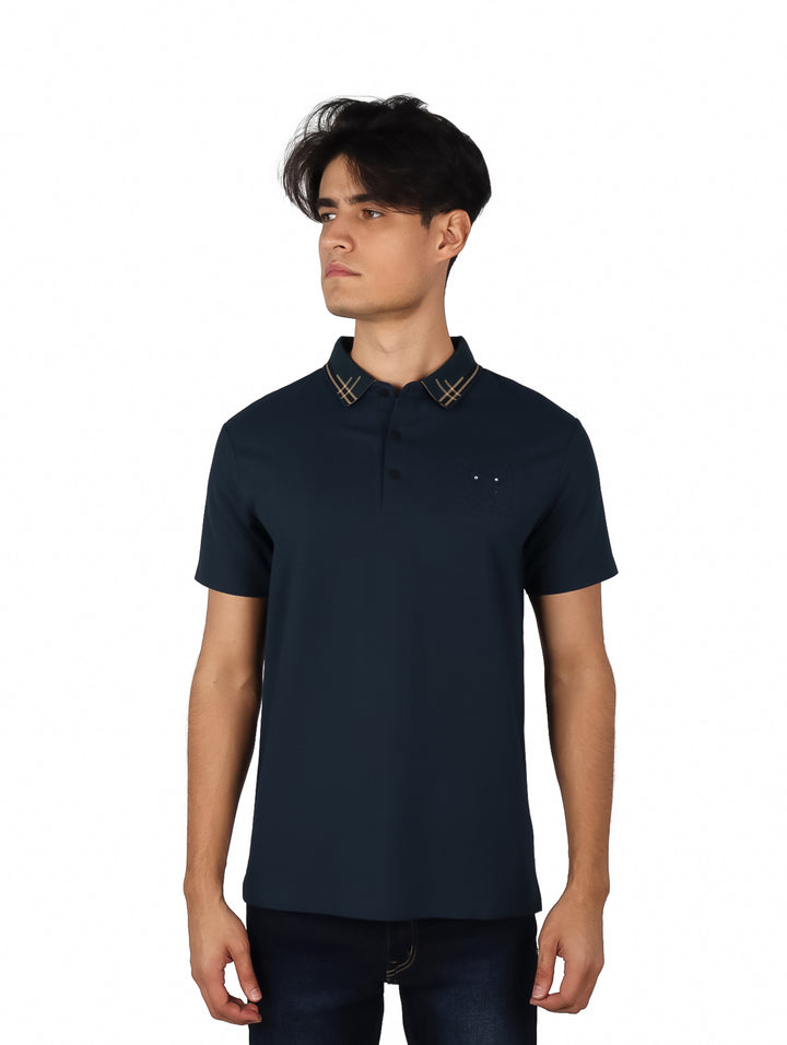 Hombre vistiendo playera polo color teal con cuello estampado en tonos cafés.