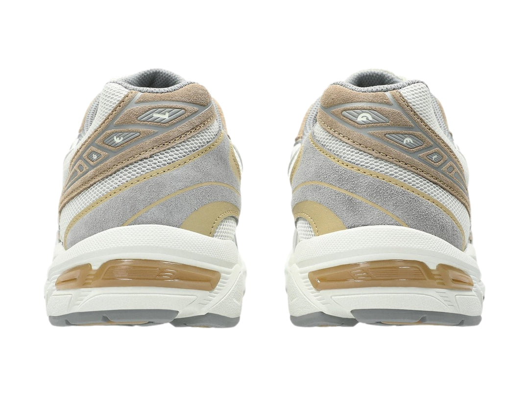 Tenis deportivos ASICS GEL-1130 en colores gris y blanco con detalles en beige, vista lateral.