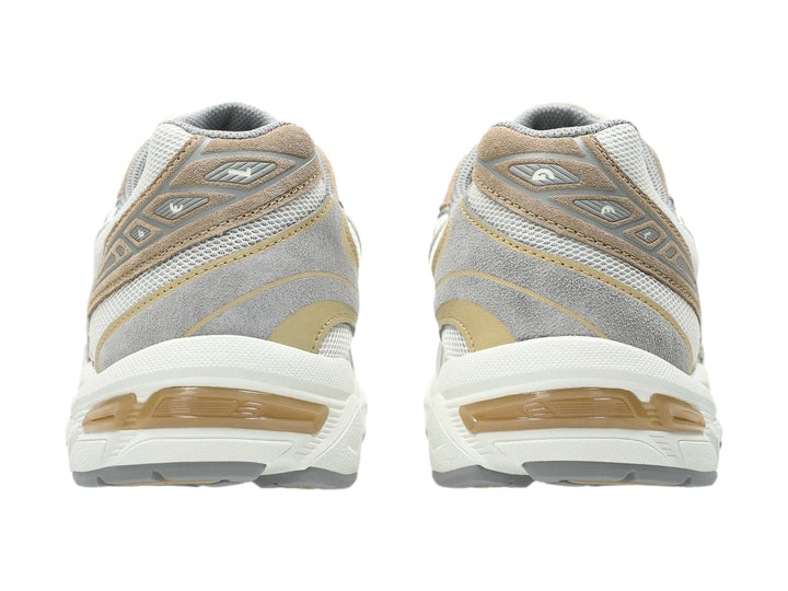 Tenis deportivos ASICS GEL-1130 en colores gris y blanco con detalles en beige, vista lateral.
