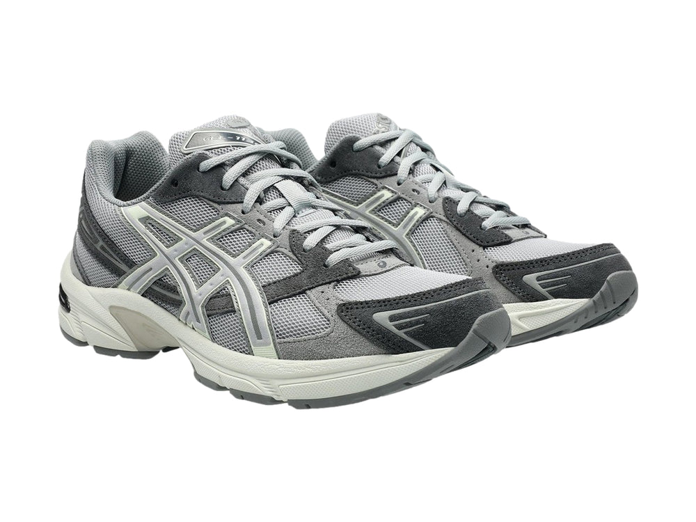 Tenis deportivos ASICS GEL-1130 en color gris cemento con detalles en blanco y suela blanca.