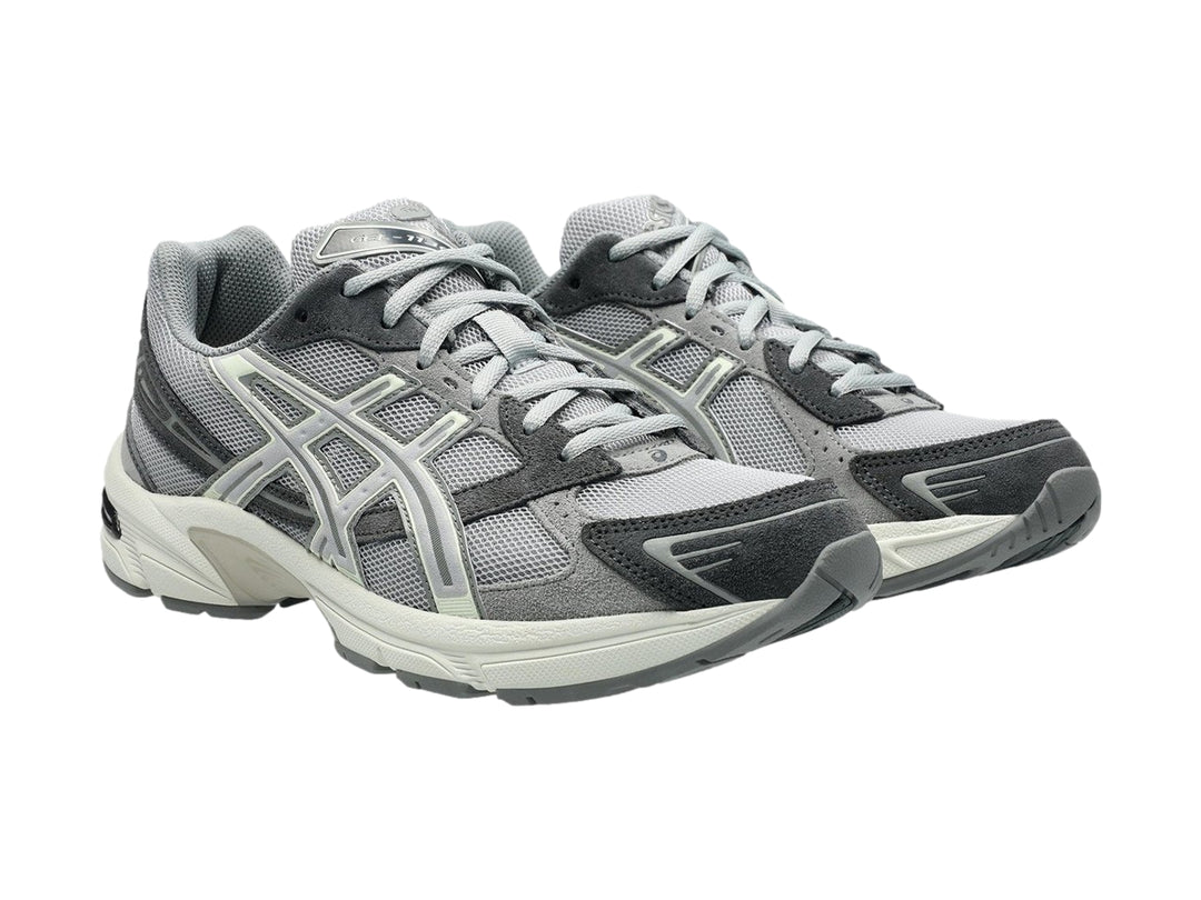 Tenis deportivos ASICS GEL-1130 en color gris cemento con detalles en blanco y suela blanca.