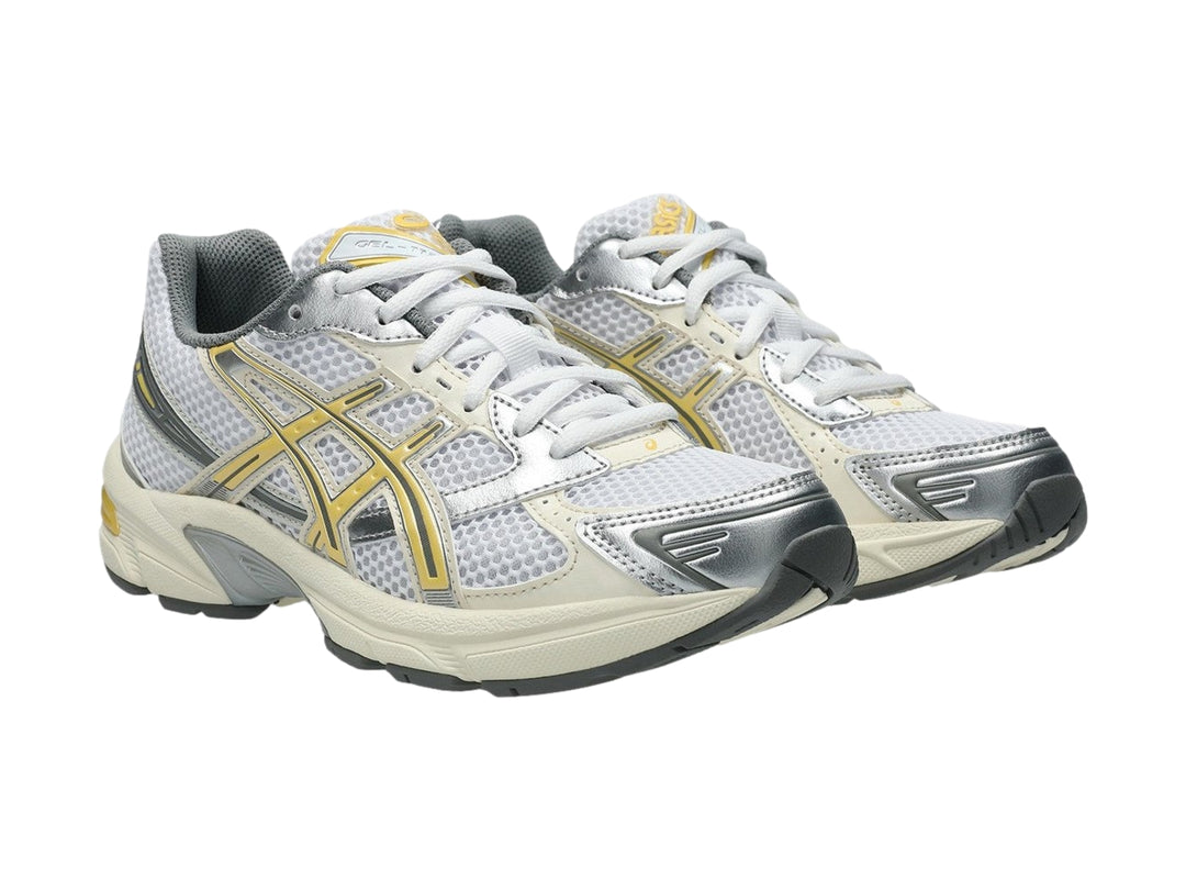 Tenis deportivos ASICS GEL-1130 color blanco con detalles en amarillo pálido y gris.