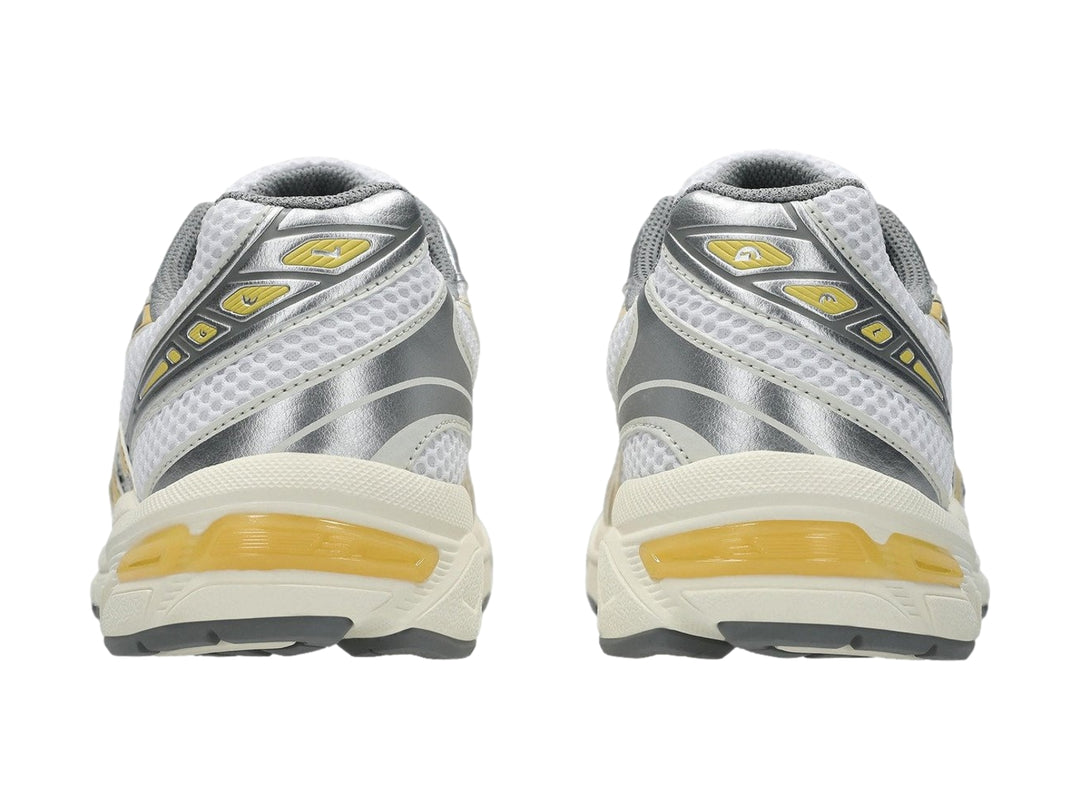 Tenis deportivos ASICS GEL-1130 color blanco con detalles en amarillo pálido y gris.