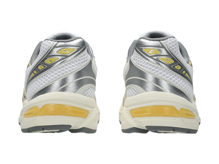 Tenis deportivos ASICS GEL-1130 color blanco con detalles en amarillo pálido y gris.
