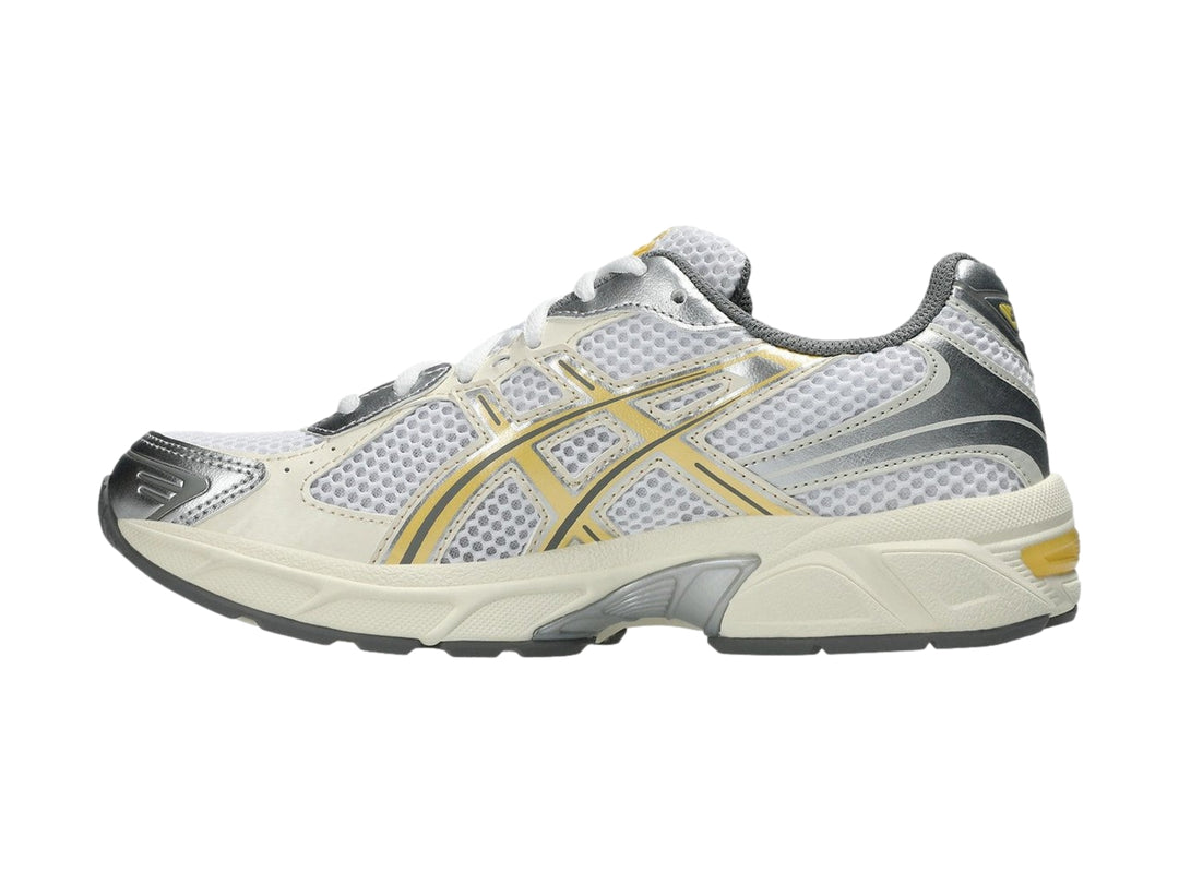 Tenis deportivos ASICS GEL-1130 color blanco con detalles en amarillo pálido y gris.