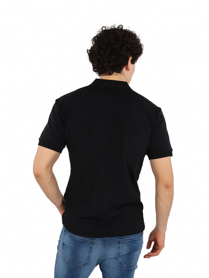 Hombre vistiendo una playera polo de color negro de manga corta.