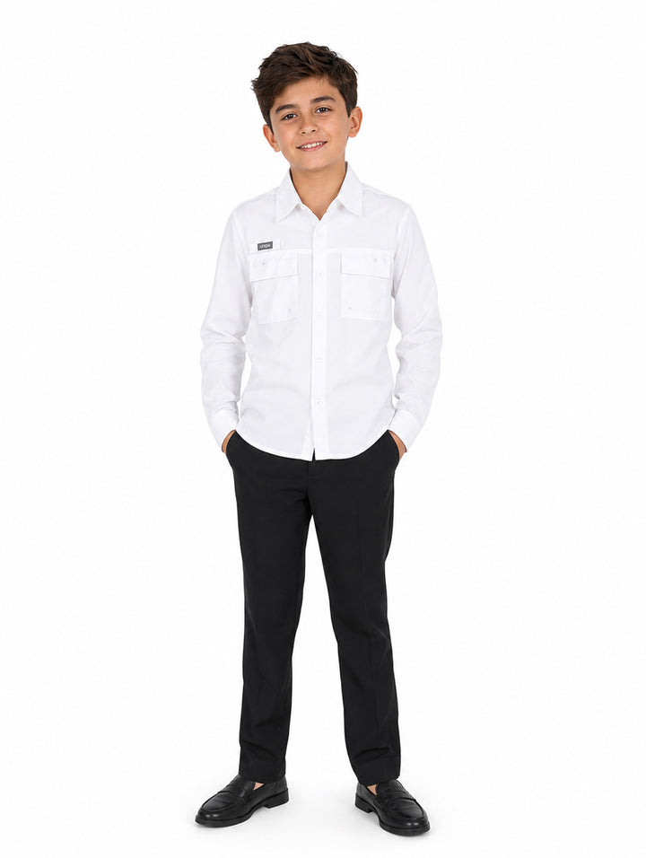 Niño vistiendo una camisa blanca de manga larga y pantalones negros sobre fondo blanco.