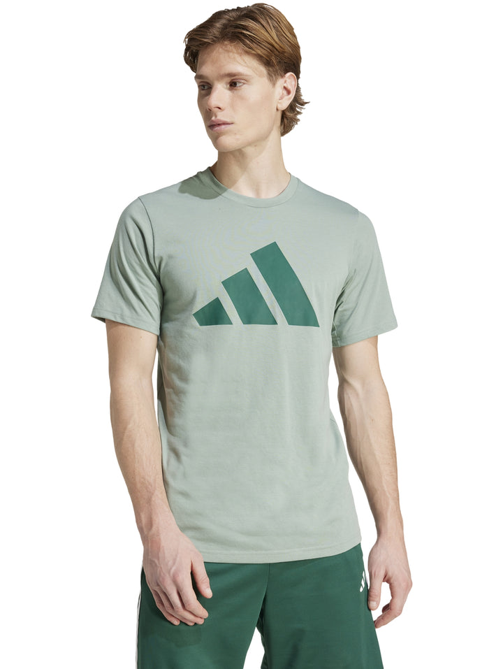 Hombre vistiendo playera deportiva Adidas color verde claro y pantalones deportivos verde oscuro.
