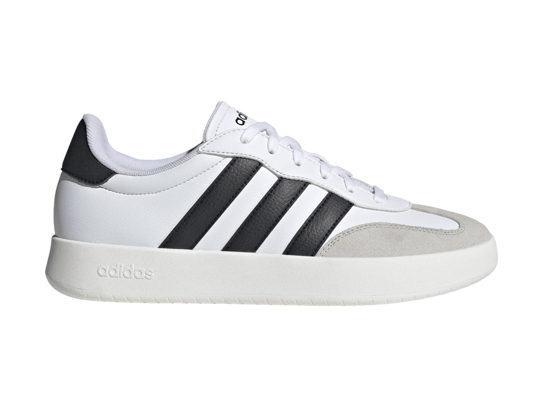 Tenis Adidas blancos con tres franjas negras laterales y punta gris.