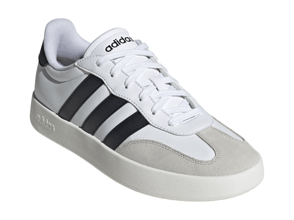 Tenis Adidas blancos con tres franjas negras laterales y punta gris.