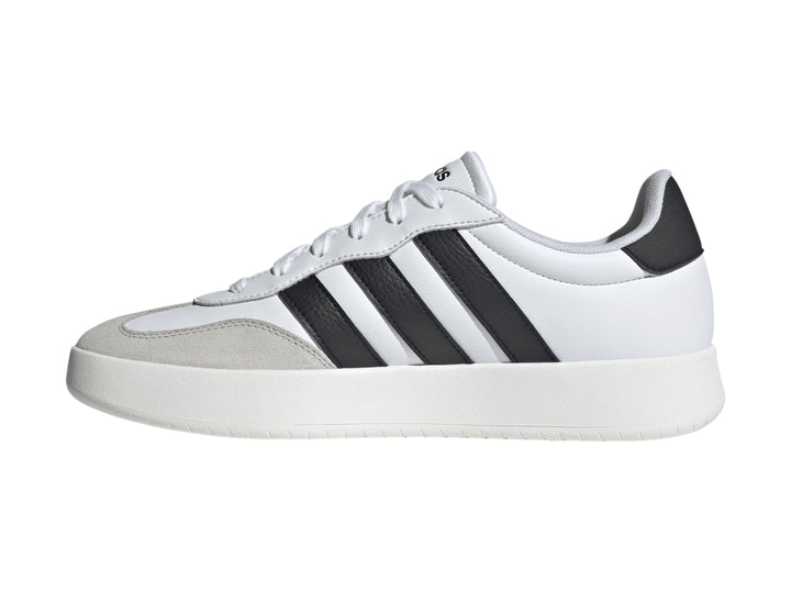 Tenis Adidas blancos con tres franjas negras laterales y punta gris.