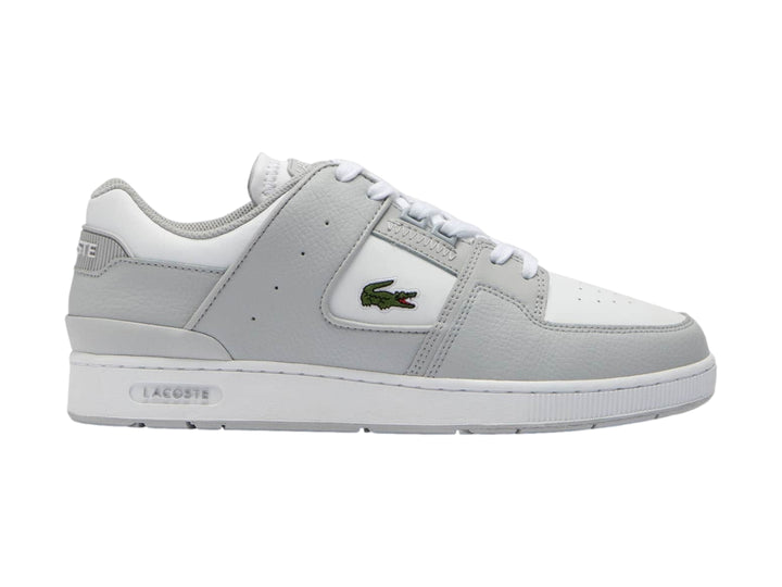 Tenis Lacoste Court Cage en color gris claro y blanco con logotipo de cocodrilo verde.