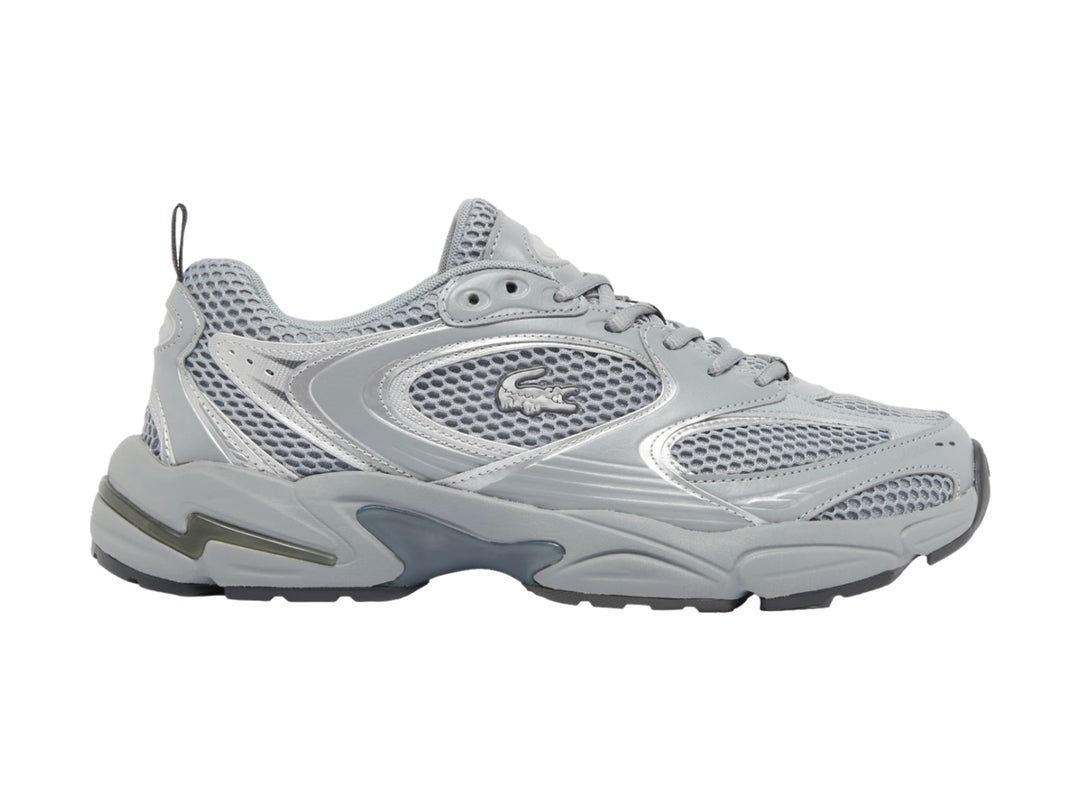 Tenis deportivos Lacoste color gris y plateado con suela gruesa y detalles de malla.