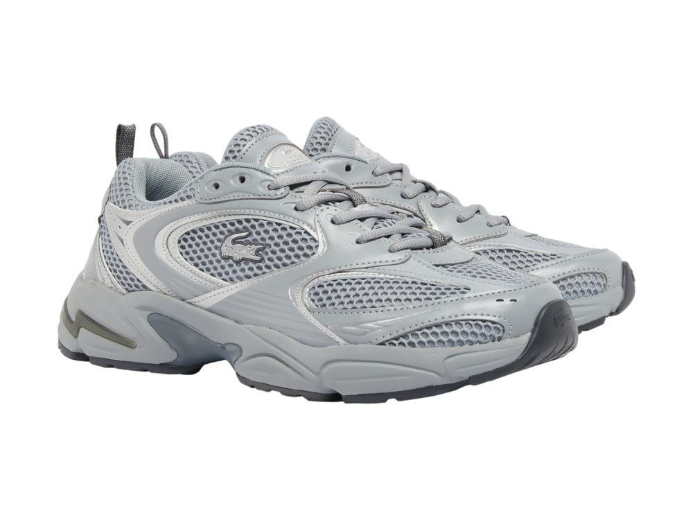 Tenis deportivos Lacoste color gris y plateado con suela gruesa y detalles de malla.