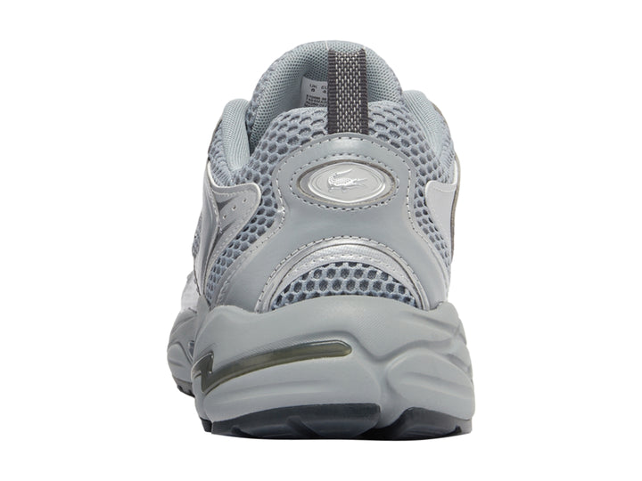 Tenis deportivos Lacoste color gris y plateado con suela gruesa y detalles de malla.