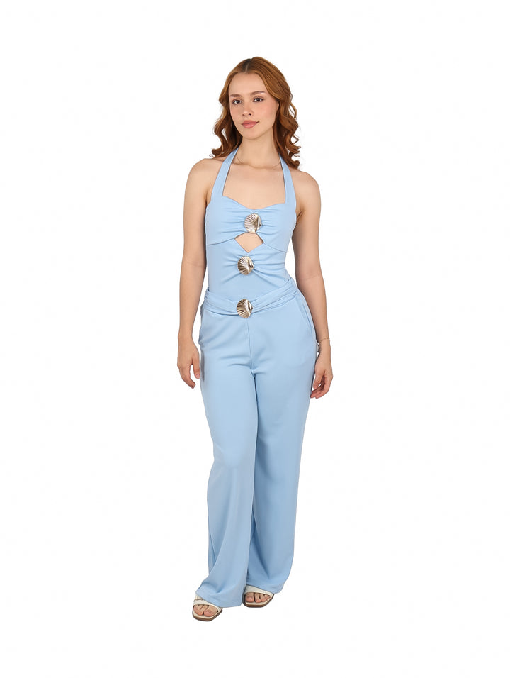 Mujer vistiendo un conjunto azul de dos piezas con top halter y pantalones anchos con detalles de conchas.