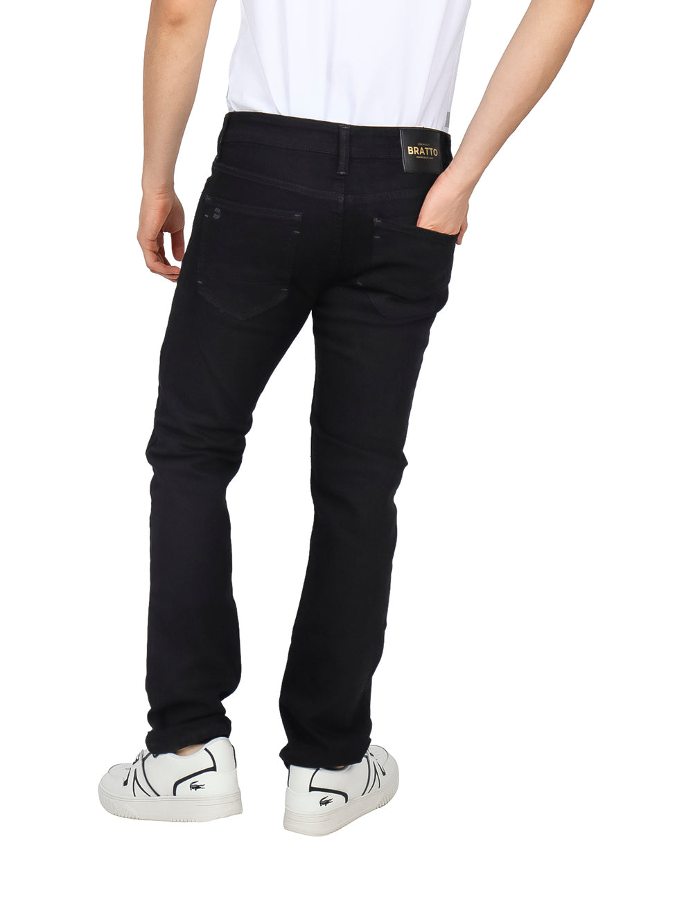 Hombre vistiendo jeans negros con detalles de destrucción en las rodillas y muslos.