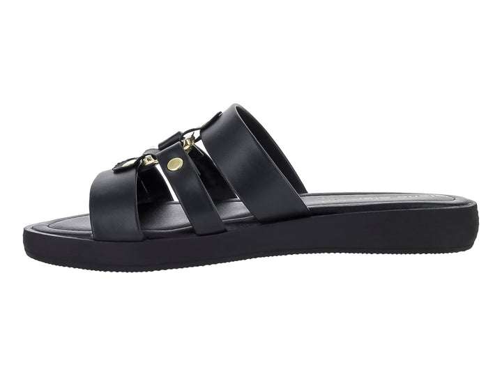 Sandalia plana color negro para hombre con tres correas y detalles metálicos dorados.