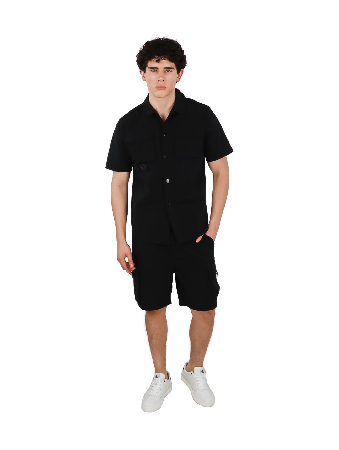Hombre vistiendo un conjunto casual de camisa y shorts color negro.
