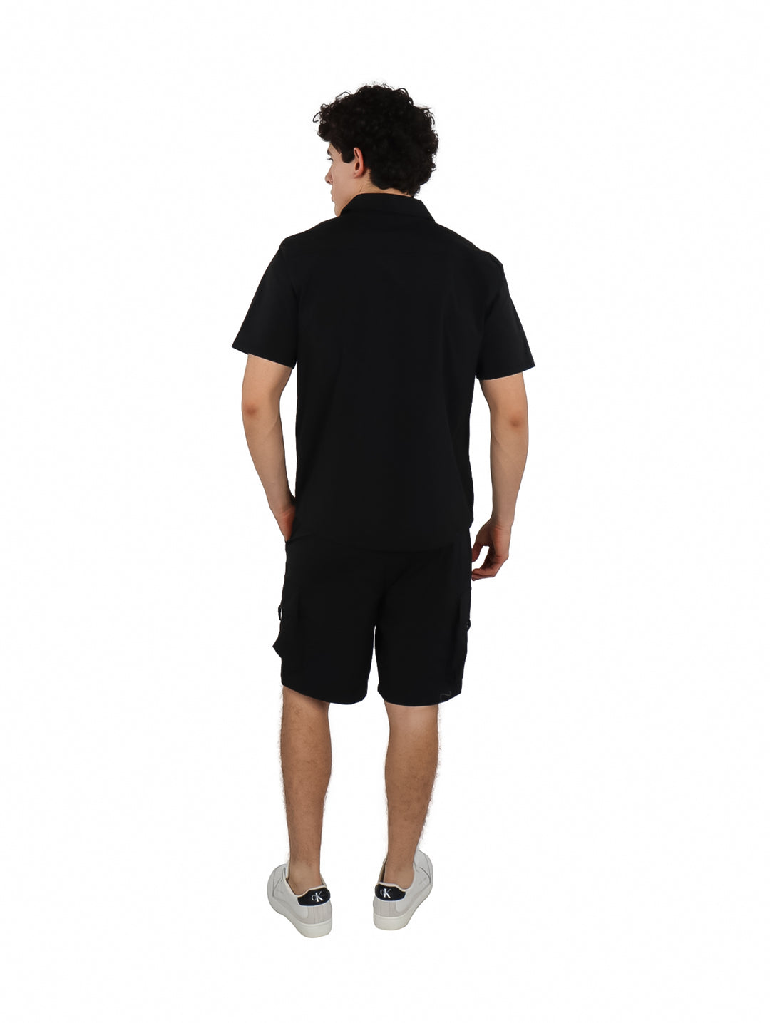 Hombre vistiendo un conjunto casual de camisa y shorts color negro.