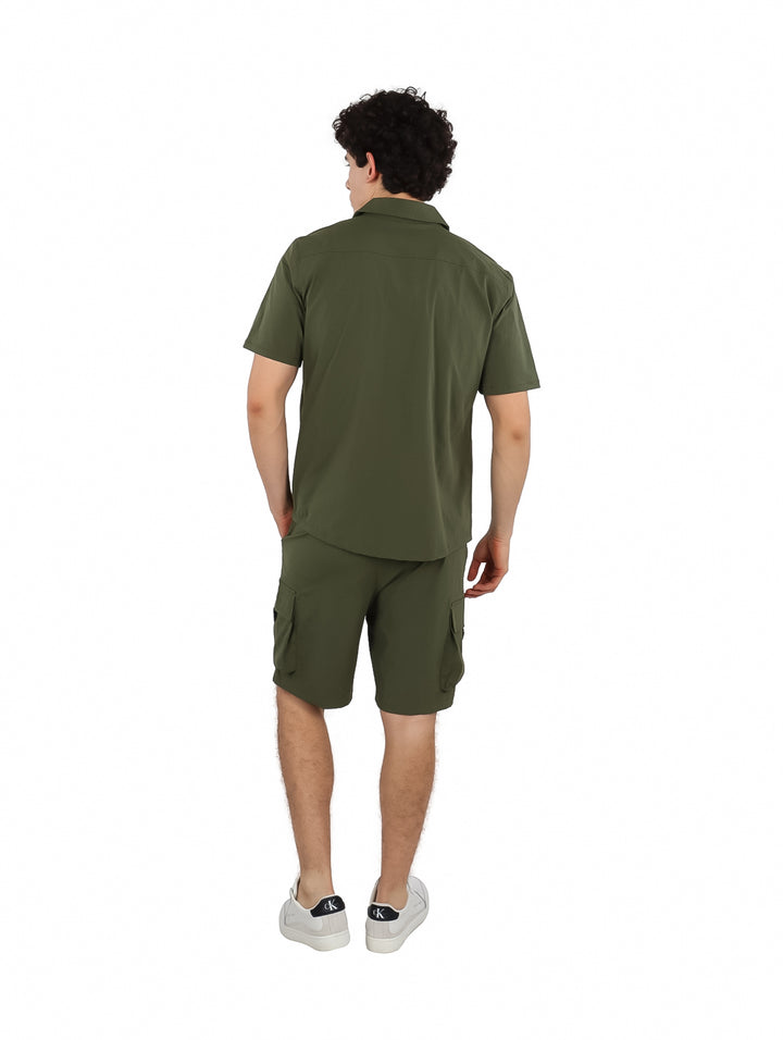 Hombre vistiendo conjunto de camisa y short cargo en color verde militar.