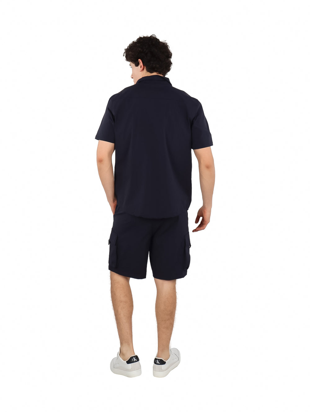 Hombre vistiendo un conjunto de camisa y shorts color azul marino.