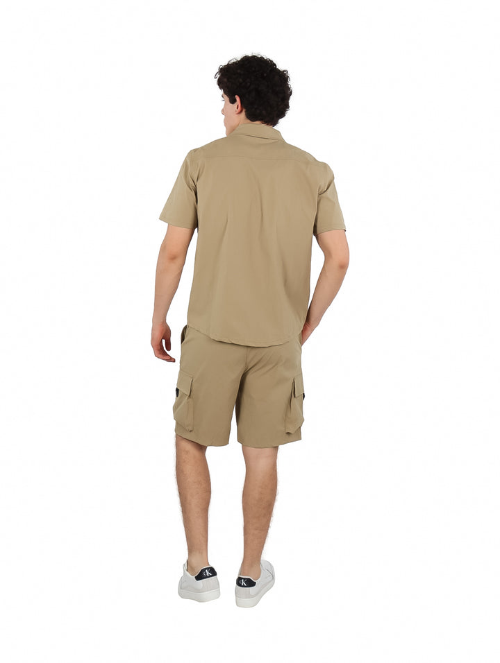 Hombre vistiendo un conjunto de camisa de manga corta y short cargo en color khaki.