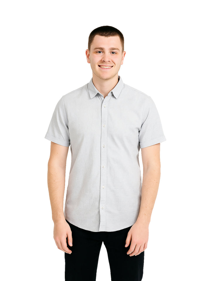 Hombre vistiendo una camisa casual de color gris de manga corta y cuello.