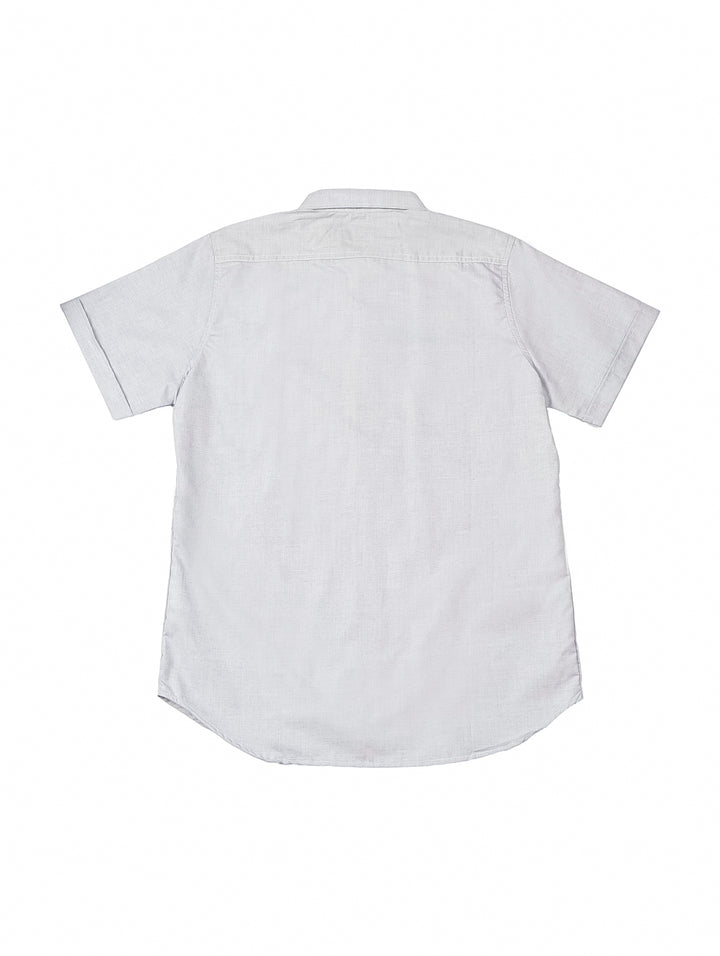 Hombre vistiendo una camisa casual de color gris de manga corta y cuello.