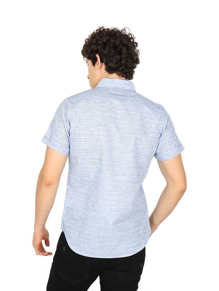 Hombre vistiendo una camisa de manga corta con estampado de rayas finas en color azul y blanco.