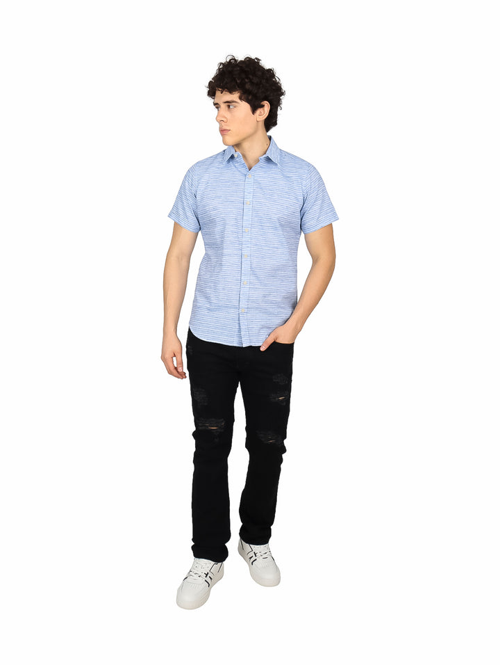 Hombre vistiendo una camisa de manga corta con estampado de rayas finas en color azul y blanco.