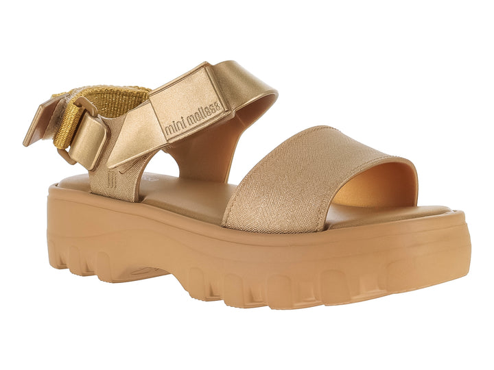 Sandalia Mini Melissa color oro con plataforma gruesa y suela dentada para niños.