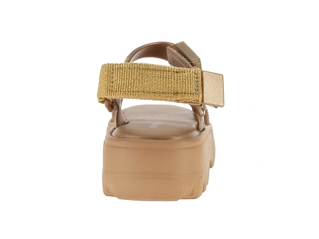 Sandalia Mini Melissa color oro con plataforma gruesa y suela dentada para niños.