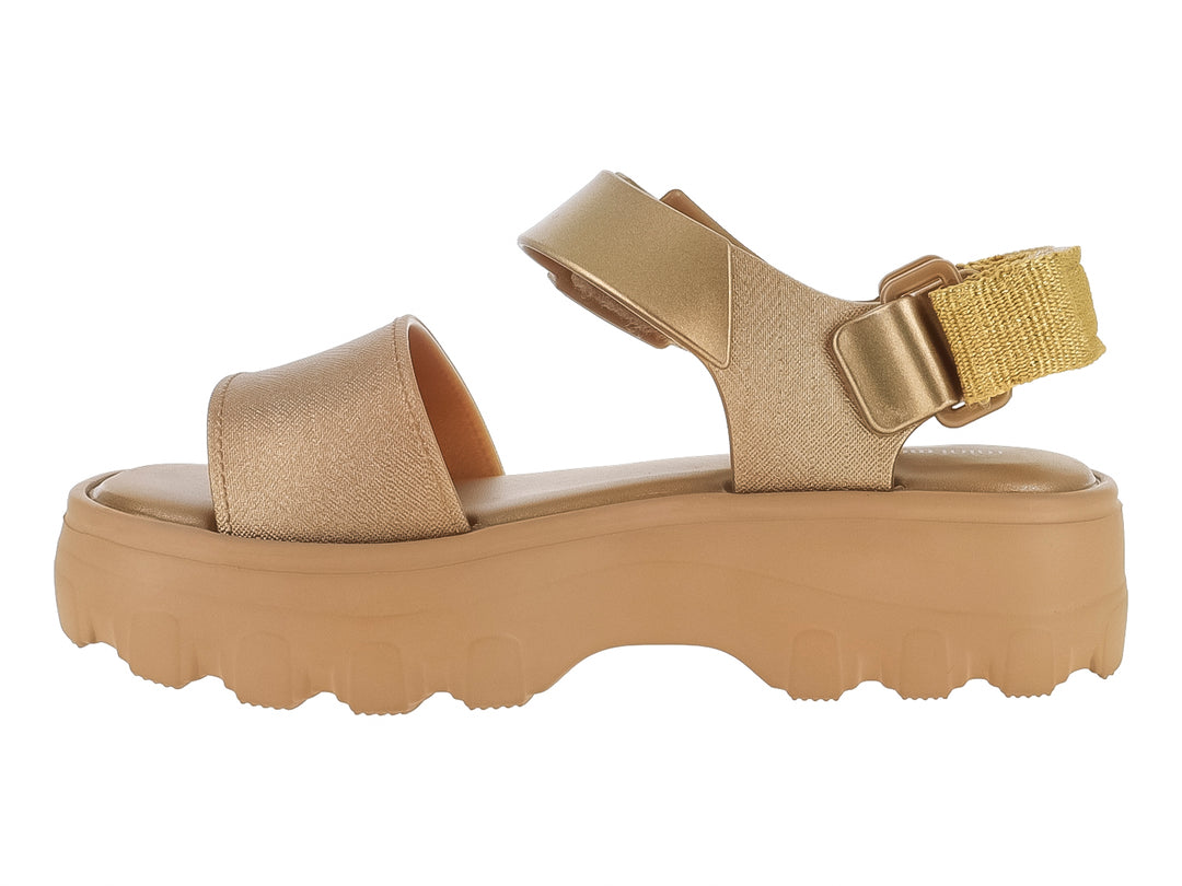 Sandalia Mini Melissa color oro con plataforma gruesa y suela dentada para niños.