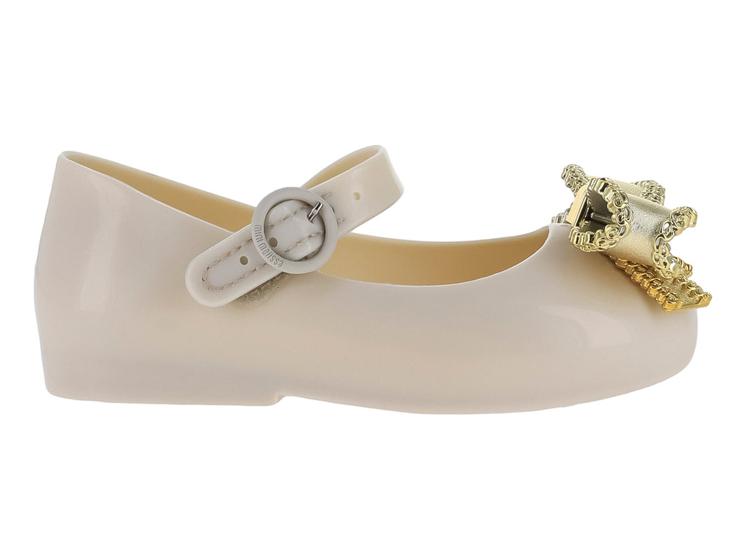 Zapato infantil Mini Melissa color beige con moño dorado y correa ajustable.