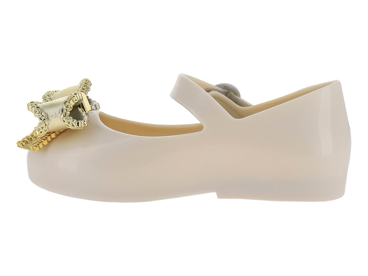 Zapato infantil Mini Melissa color beige con moño dorado y correa ajustable.